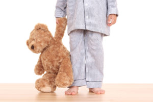 Little boy with teddy bear trying not to go to bed